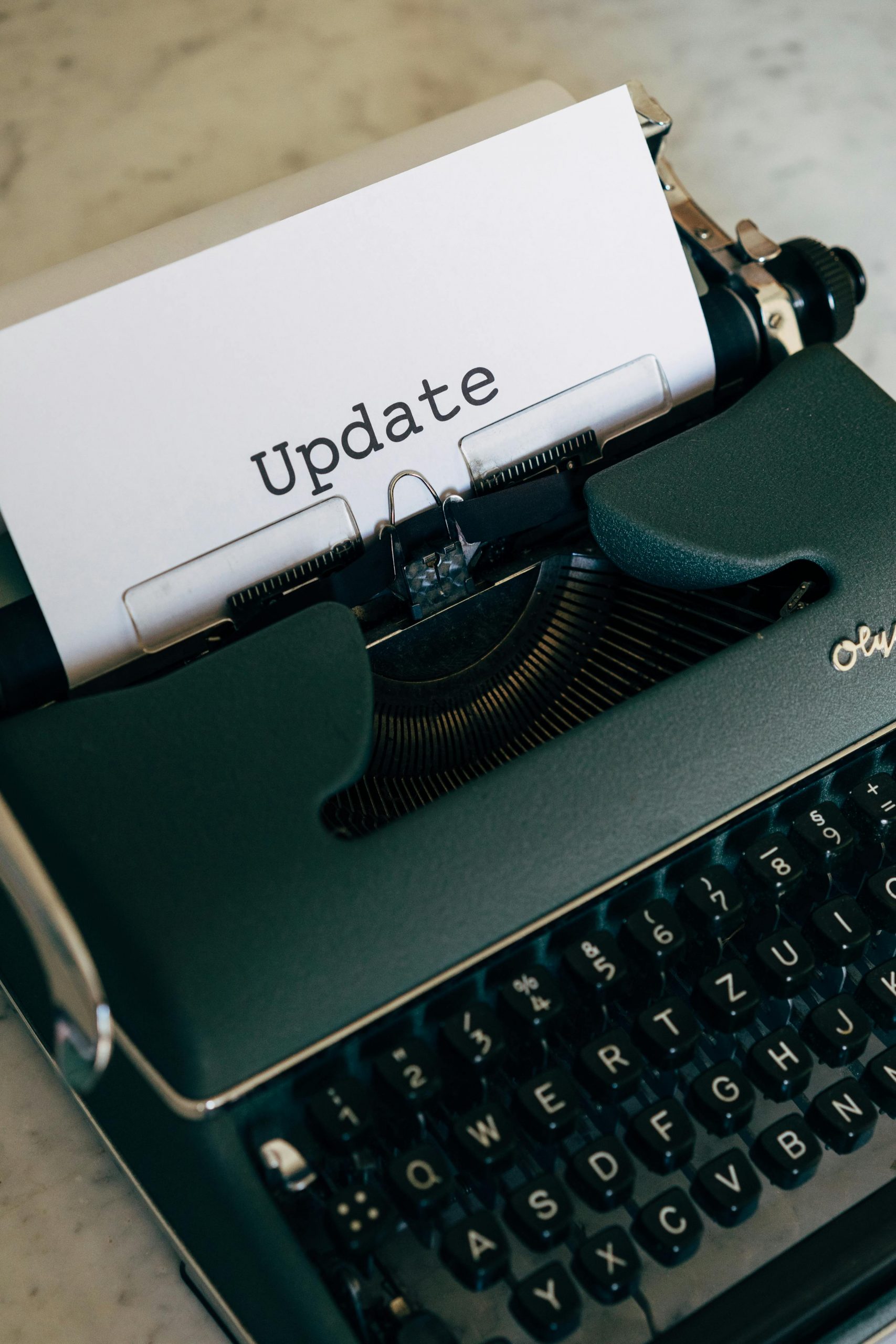 A close-up of a vintage typewriter with paper displaying the word 'Update'.